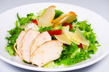 Light Chicken Caesar Salad with Croutons and Parmesan Cheese, Served on White Plate, Close-Up, Healthy and Delicious Lunch for Restaurant Menu.