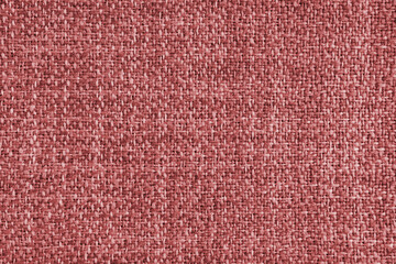 Upholstery red colored jacquard fabric coarse weave texture. Textile background, furniture textile material, wallpaper, backdrop. Cloth structure close up, macro