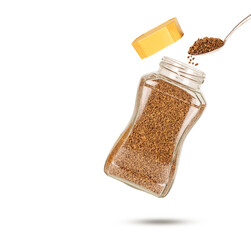 Instant coffee bottle and spoon filled with freeze dry instant coffee isolated on white background. Close up
