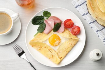 Delicious crepe with egg, ham and parmesan cheese served on white wooden table, flat lay