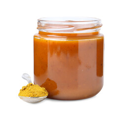 Tasty curry sauce in glass jar and spoon with powder isolated on white
