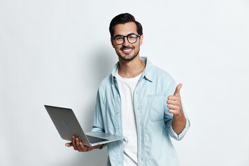 Smiling man with laptop show thumb up gesture wear glasses casual denim shirt white background...