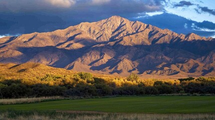 Sunrise over a remote mountain range with dark shadows and bright light breaking through