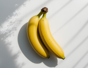A group of 2 fresh yellow and green banana arranged closely together on a clean white background