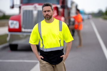 Happy confident male driver standing in front on his truck looking at camera. Portrait of happy...