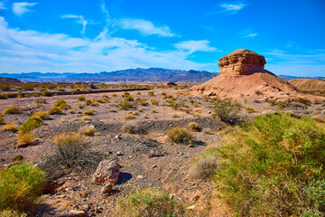Desert Rock Formation with Mountains and Blue Sky Eye-Level Perspective