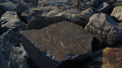 Gray rocks piled high on shore, blurred background