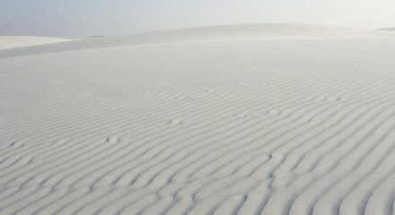 Obraz premium Vast Pearly White Sand Dunes with Subtle Flowing Patterns in Desert Landscape