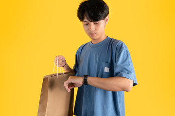 a man with brown shopping bag while looking at his watch