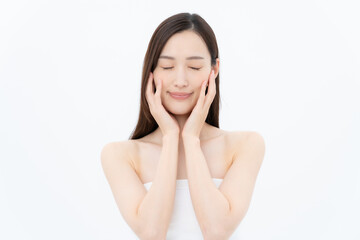 Fototapeta premium 白バックでスキンケアをするロングヘアの若い女性