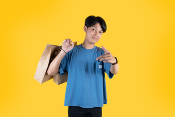 a man with brown shopping bag in his shoulder while pointing to the camera and smile