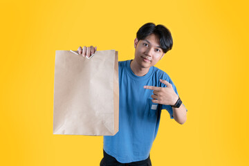 a man showing his brown shopping bag and pointing at it