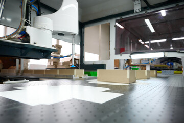 Production process of decorative cardboard packaging with precision cutting at a bustling factory