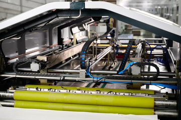 Inside the intricate workings of a folding machine at a decorative box factory, highlighting...