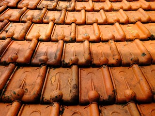 old roof tiles.full frame roof surface of the house made of red brick or classic clay tiles. Rough...