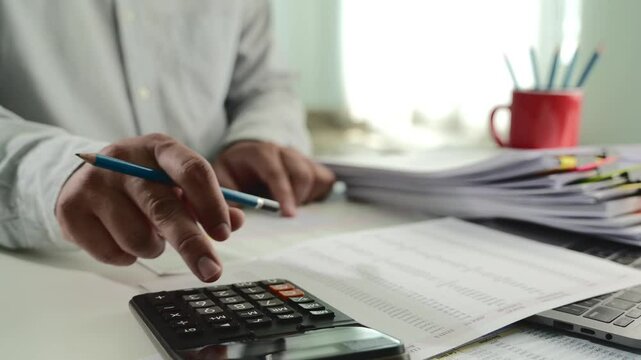 Businessman calculating balance prepare tax  uses a laptop and calculator to inspect financial reports, plan budgets, manage income, and track expenses			
