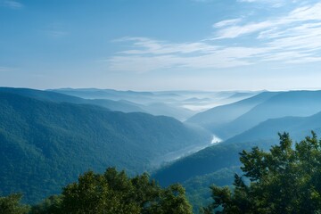 Obraz premium Misty Mountain Landscape with River, Forest Canopy, and Blue Sky Scenery