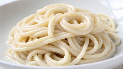 Delicious plate of soft, creamy spaghetti noodles on a white dish.