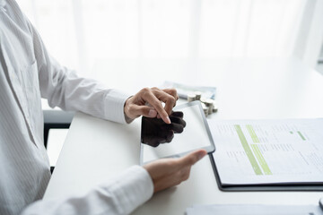 Business man holding digital tablet using Stock market application and reviews finances and manages budget with money cash