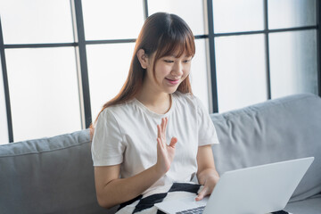 Obraz premium Asian woman video call with family by using laptop