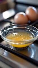 Clarified Butter in Glass Bowl on Stovetop with Eggs
