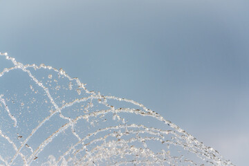 Splashes and jets of water against light background.
