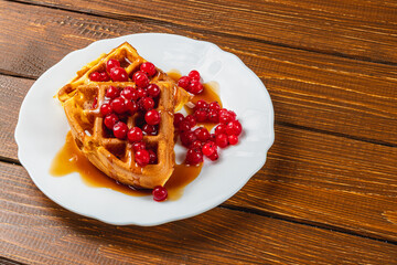 Delicious waffles topped with berries and syrup served