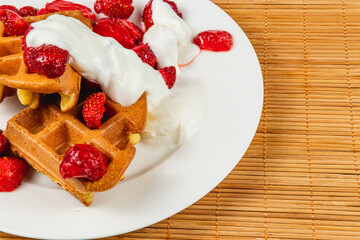 Delicious waffles topped with strawberries and cream