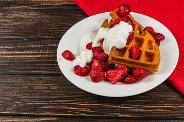 Delicious waffles topped with fresh strawberries and cream