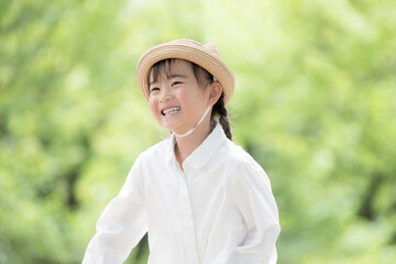 新緑の中屋外で笑顔の女の子