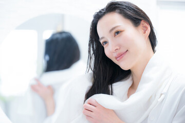 お風呂上りに髪の毛をタオルドライする女性