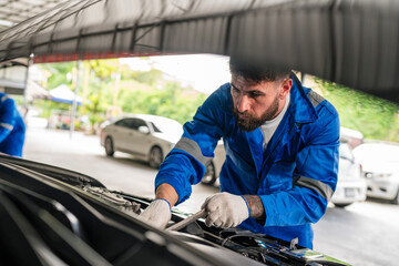 Male Auto mechanic are checking auto engine is problems.