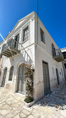 Traditional White Stone House With Wooden Shutters And Balcony On Sunny Day, Mediterranean Island, Perfect For Real Estate, Travel, Architecture, Summer Tourism, And Historic Property Promotion