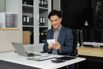 Naklejka premium Male businessman working on desk office with using a calculator to calculate the numbers.
