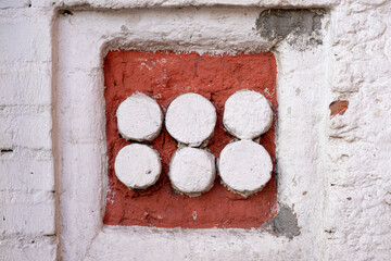 Wall Decoration Featuring Six White Circles on a Red Brick Background