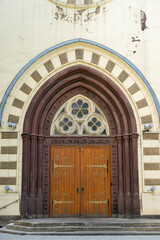 Gothic Church Entrance with Decorative Wooden Doors and Stone Arched Details