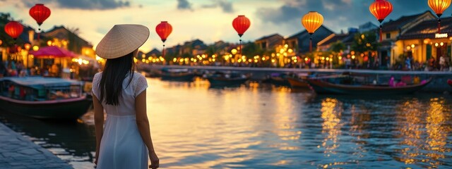 Woman in Hoi An, Vietnam at sunset, admiring the river and lanterns.