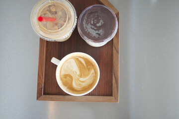Coffee and desserts served on a wooden tray in a cozy cafe