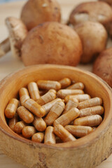 Natural health supplements made from mushrooms in wooden bowl
