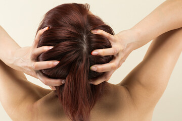 Naklejka premium 若いアジア人の女性は頭皮をマッサージしています。