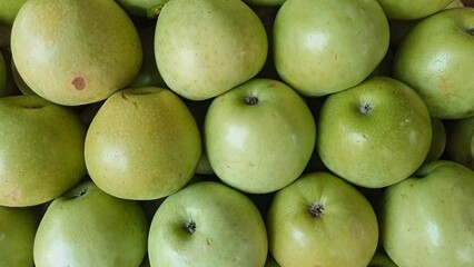 Fresh green apples. Shiny green apple close-up pile for background. Pile of green apples in the market