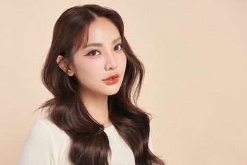 A beautiful young Asian woman with clean, fresh skin against a beige background. Skincare, facial...