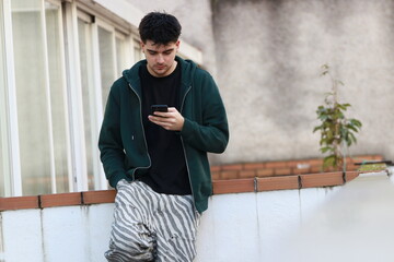 young man or student with mobile phone outdoors