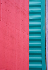 abstract vertical background backdrop image of close cropped smooth red and corrugated turquoise containers small strip of purple on right side colorful divided columns with blank red space for type 