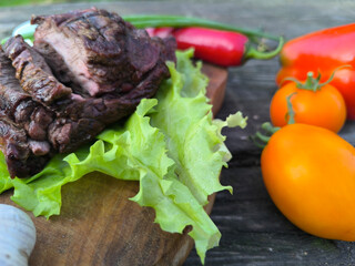 Lamb steak surrounded by vegetables and salad. High-quality photo