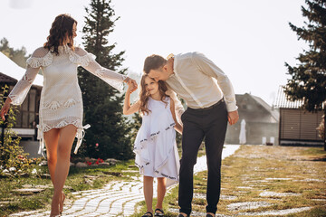 Family mother, father and daughter are beautiful and happy together, in white clothes, on a walk