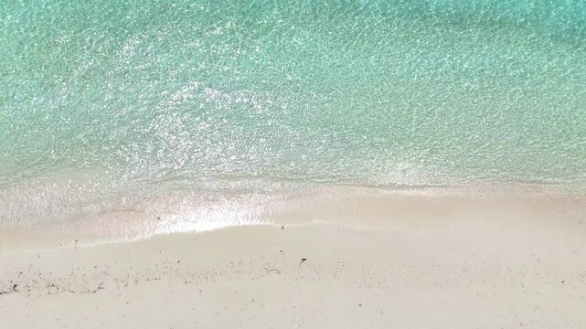 Top view of tropical beach with white sand and clear turquoise water in natural sunlight, minimalist peaceful scenery, relaxation, hotel, summer escape, Maldives island vacation