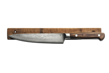 A rustic handcrafted chef s knife with a weathered steel blade rests on a dark wood magnetic strip against a black background showcasing on transparent background