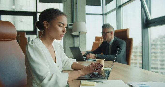 Focused businesswoman typing on laptop in office