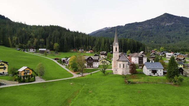 Aerial view of historic church in scenic lush green Gosau village in Austria.